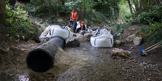 Calage d'une canalisation ECOPAL avec de l'argile, côté amont. Partie qui va recevoir le bord d'attaque du batardeau souple Water-Gate©