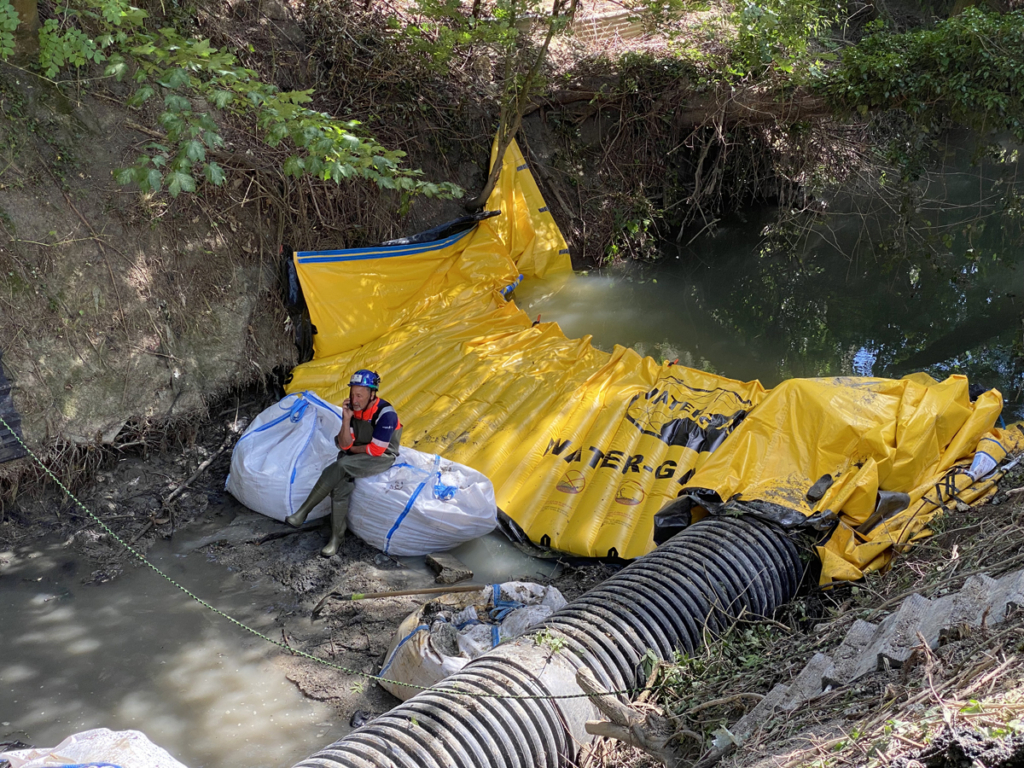 Chef de chantier assis sur un big bag de blocage du batardeau amont, zone mise en assec sur le Cubry à Épernay